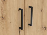 Nahaufnahme von zwei schwarzen Griffen auf einer Holzoberfläche eines Mehrzweckschranks, von vorne betrachtet.