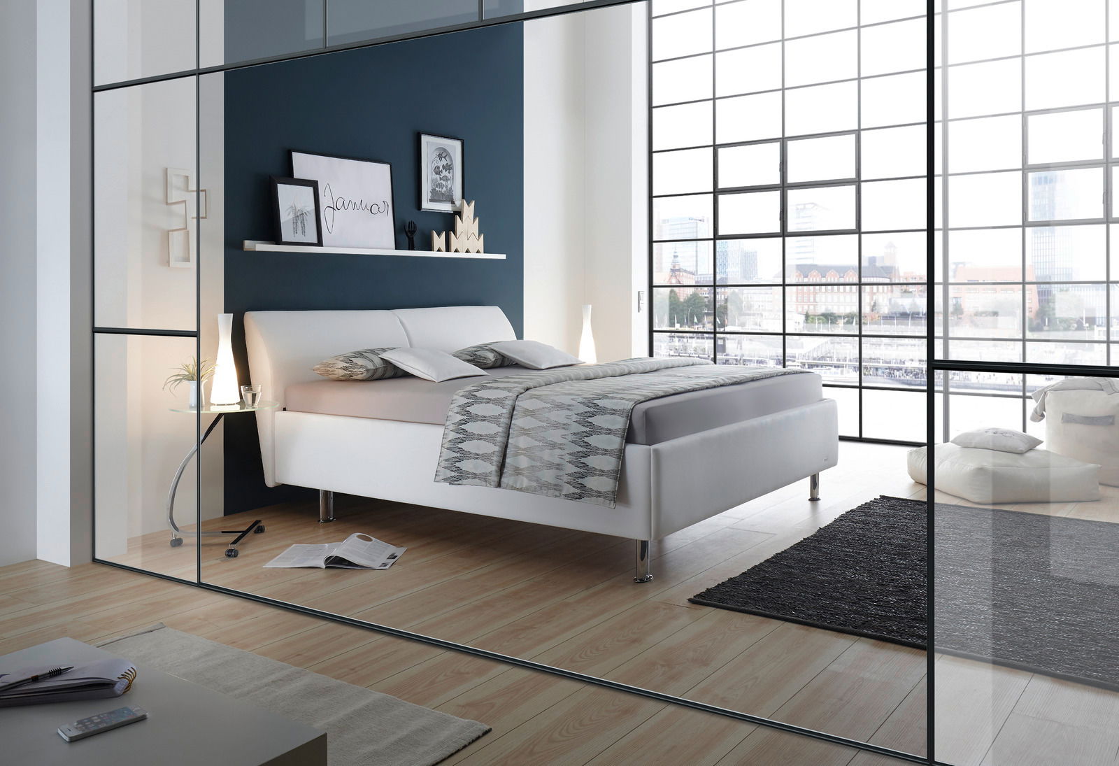 Modernes Polsterbettgestell in einem stilvollen Schlafzimmer mit großen Fenstern und Holzboden, seitliche Perspektive