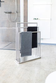 Moderner Handtuchständer aus der Serie WALDI von Zurbrüggen, aus Edelstahl mit zwei Handtüchern, in einem Badezimmer mit Blick auf die Duschkabine.