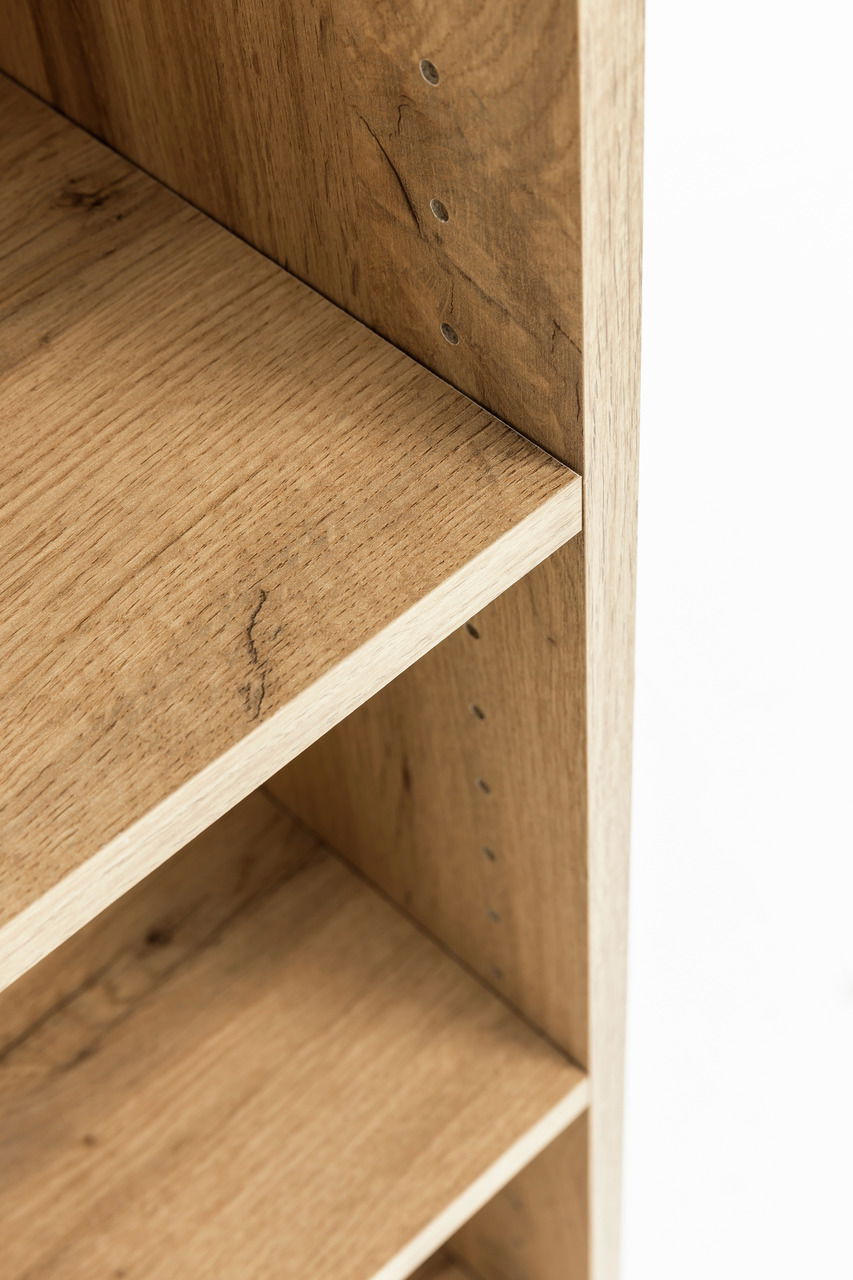 Nahaufnahme eines Hängeschranks aus Holz mit verstellbaren Regalböden, seitliche Perspektive.
