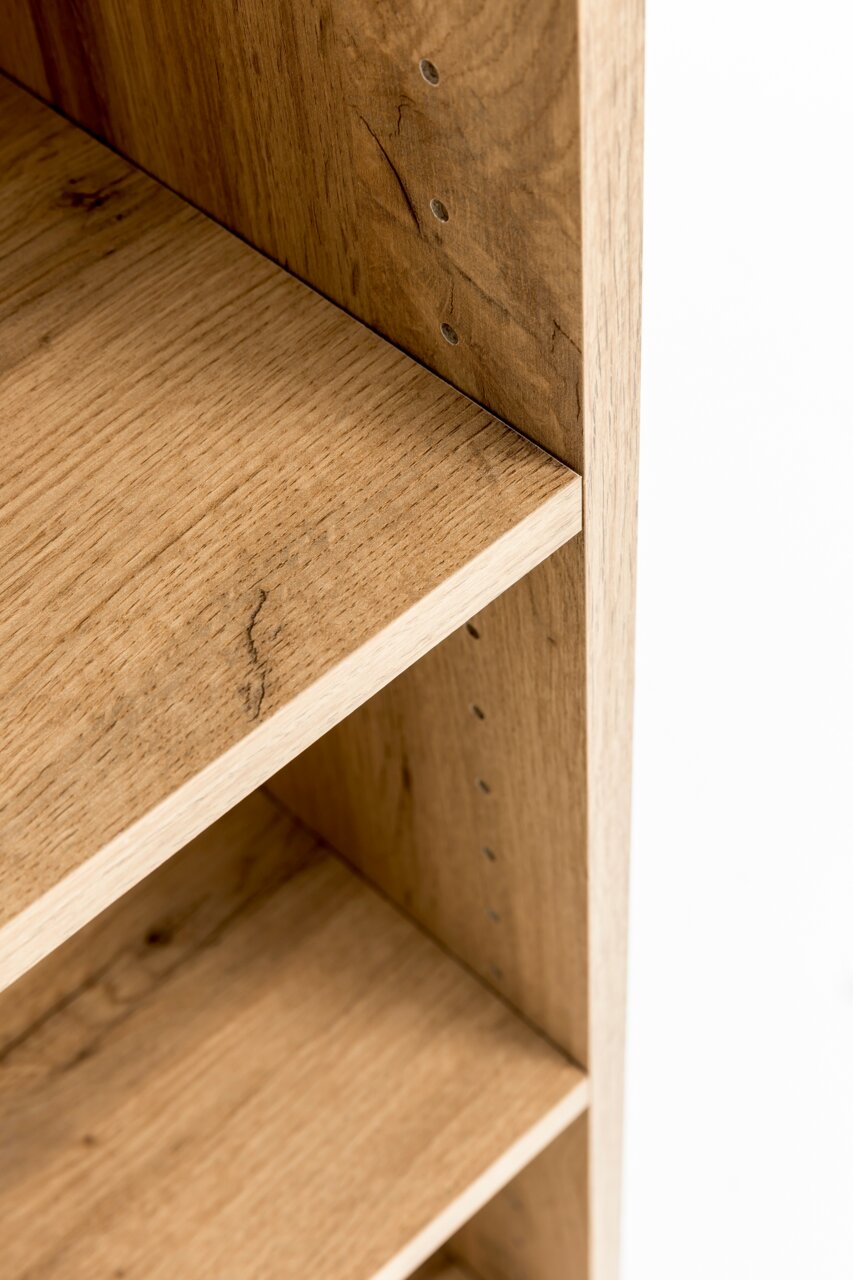 Nahaufnahme eines Hängeschranks aus Holz mit verstellbaren Regalböden, seitliche Perspektive.