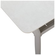 Nahaufnahme eines weißen Gartentisches aus der Vogelperspektive, zeigt die Tischkante und ein Tischbein.