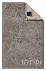 Graues Gästetuch mit eingewebtem 'JOOP!' Logo, ausgebreitet mit umgeschlagener Ecke, die die Rückseite zeigt.