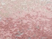Nahaufnahme eines Designer Teppichs in Rosa- und Beigetönen mit flauschiger Textur, von oben betrachtet.