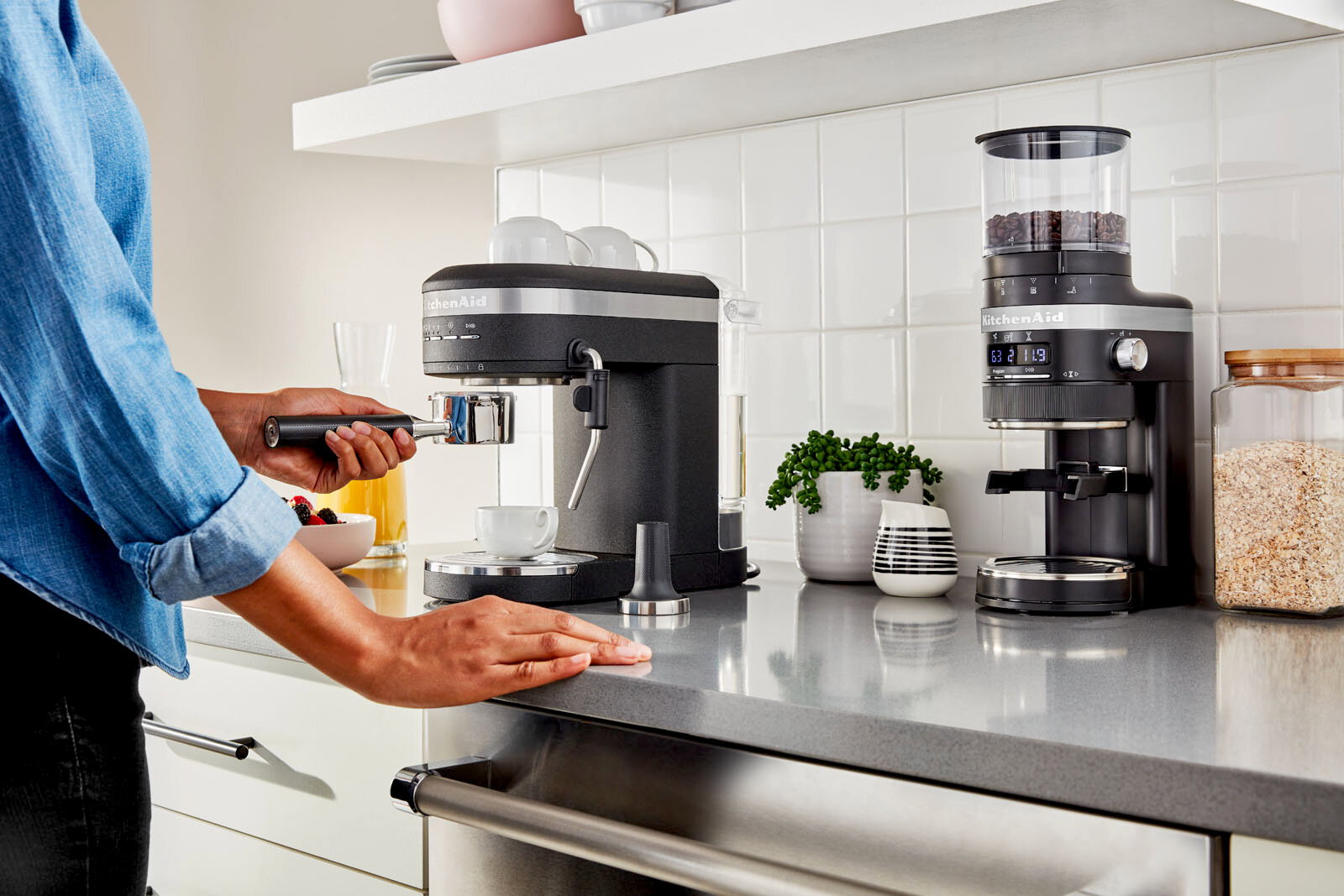 Küchenarbeitsplatte mit einer schwarzen Espressomaschine und Kaffeemühle, seitliche Perspektive