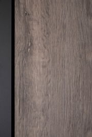 Nahaufnahme einer Holzoberfläche mit natürlicher Maserung und einem schwarzen Rand auf der linken Seite.