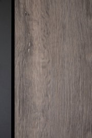Nahaufnahme einer Holzoberfläche mit natürlicher Maserung und einem schwarzen Rand auf der linken Seite.