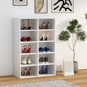 Weißes Schuhregal mit acht offenen Fächern, gefüllt mit verschiedenen Schuhen, im modernen Wohnraum – Frontansicht leicht von links.