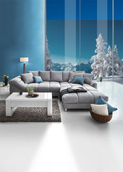 Graue Rundecke (L) in einem modernen Wohnzimmer mit Blick auf verschneite Berge durch große Fenster, Vorderansicht.