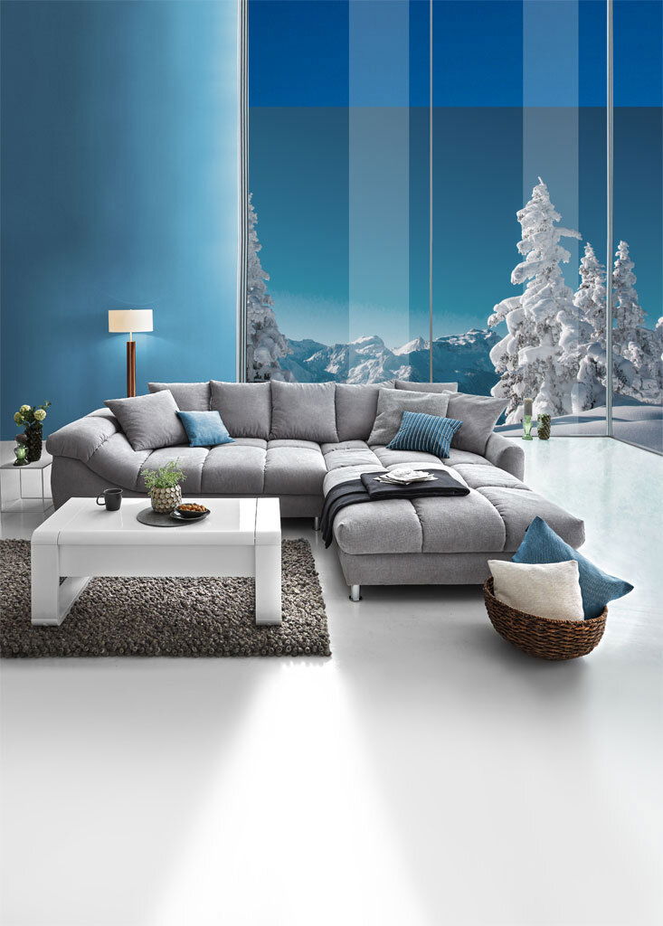 Graue Rundecke (L) in einem modernen Wohnzimmer mit Blick auf verschneite Berge durch große Fenster, Vorderansicht.