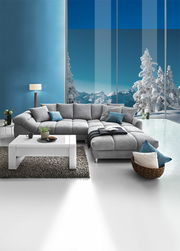 Graue Rundecke (L) in einem modernen Wohnzimmer mit Blick auf verschneite Berge durch große Fenster, Vorderansicht.