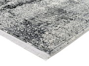 Nahaufnahme eines Designer-Teppichs mit grauem und weißem Muster, perspektivisch von der Seite aufgenommen.