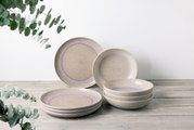 Tafelservice 8-tlg. in natürlichem Design mit sanften Beige- und Blautönen, bestehend aus flachen und tiefen Tellern, auf einem Holztisch arrangiert. Seitliche Perspektive.