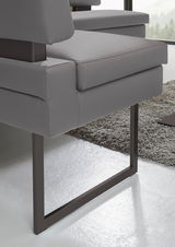 Detailansicht einer modernen grauen Eckbank mit Metallbeinen auf einem Teppichboden.