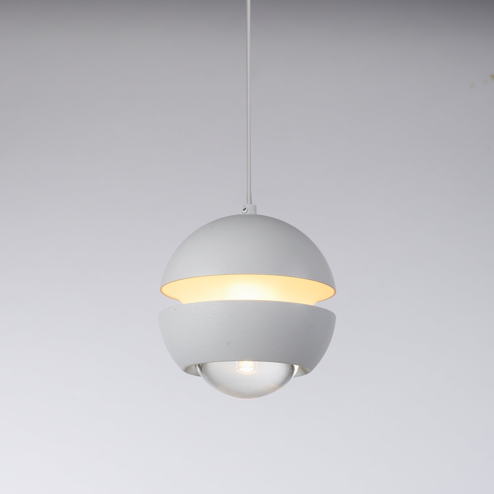 Weiße, moderne Pendelleuchte mit kugelförmigem Schirm und warmem Licht, freigestellt vor hellem Hintergrund, Ansicht leicht von unten in Frontperspektive