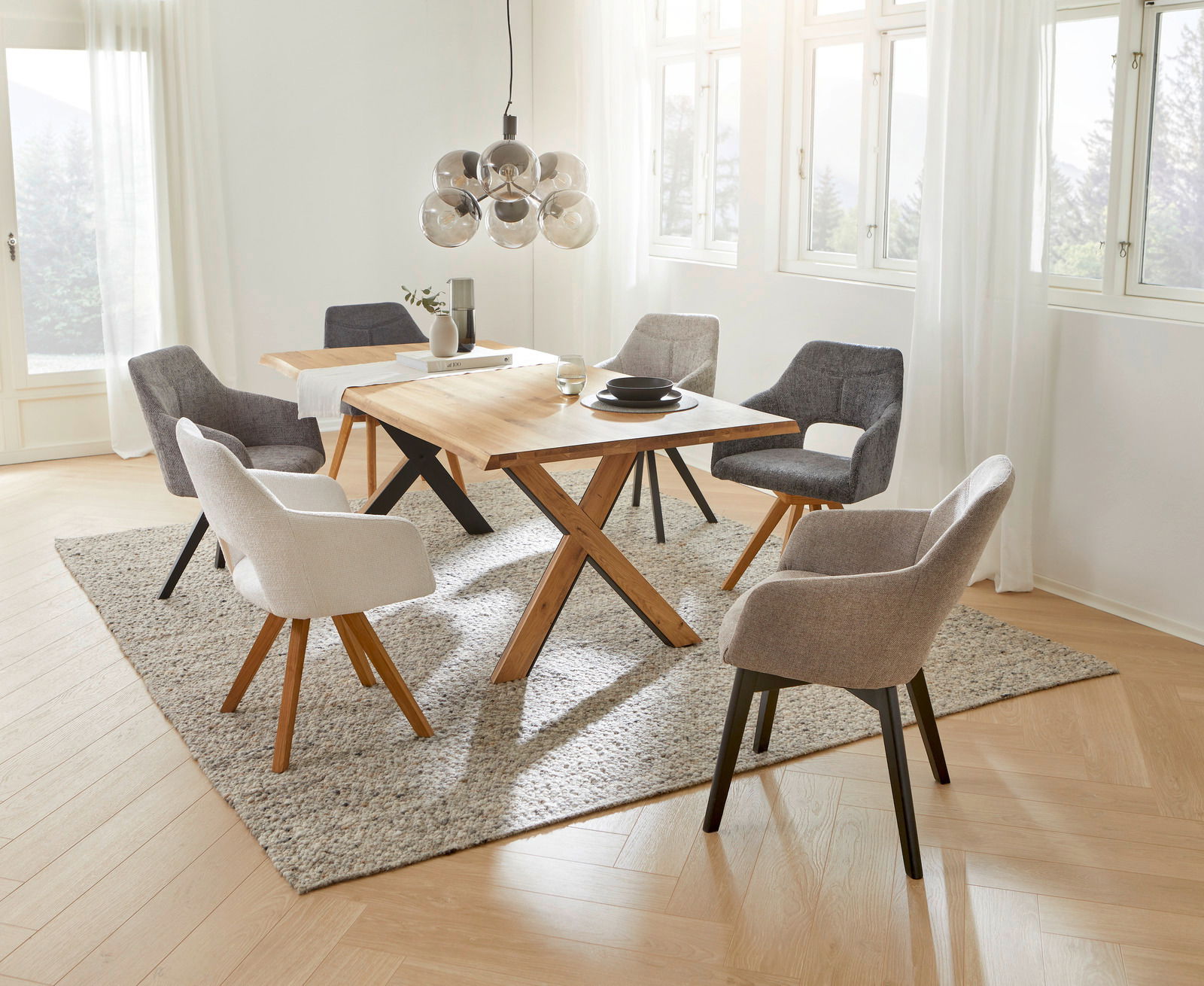 Esszimmer mit modernen Sesseln der Serie EVITA von Voleo, um einen Holztisch arrangiert. Helle und einladende Atmosphäre mit Blick aus der Vogelperspektive.