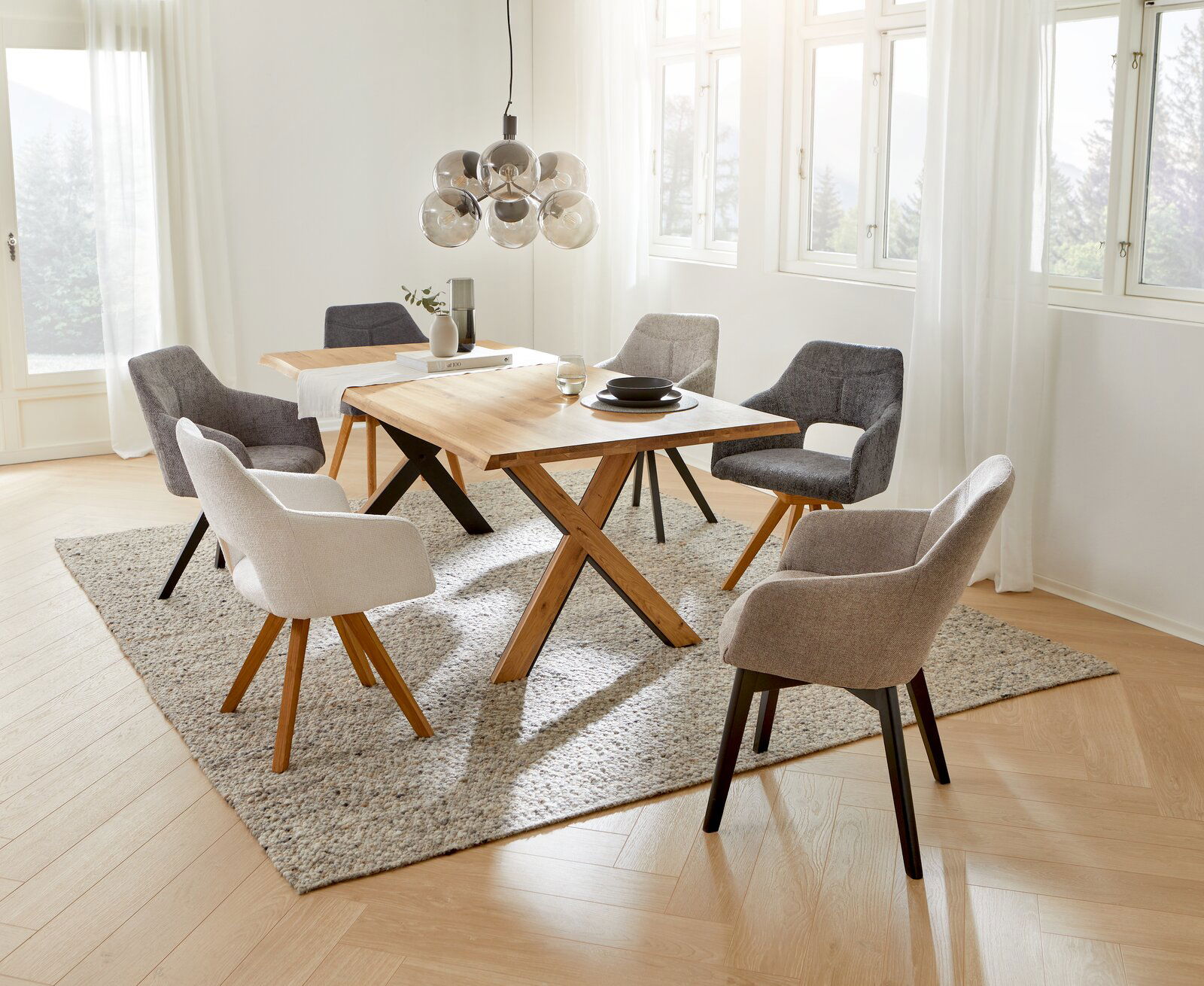 Esszimmer mit modernen Sesseln der Serie EVITA von Voleo, um einen Holztisch arrangiert. Helle und einladende Atmosphäre mit Blick aus der Vogelperspektive.