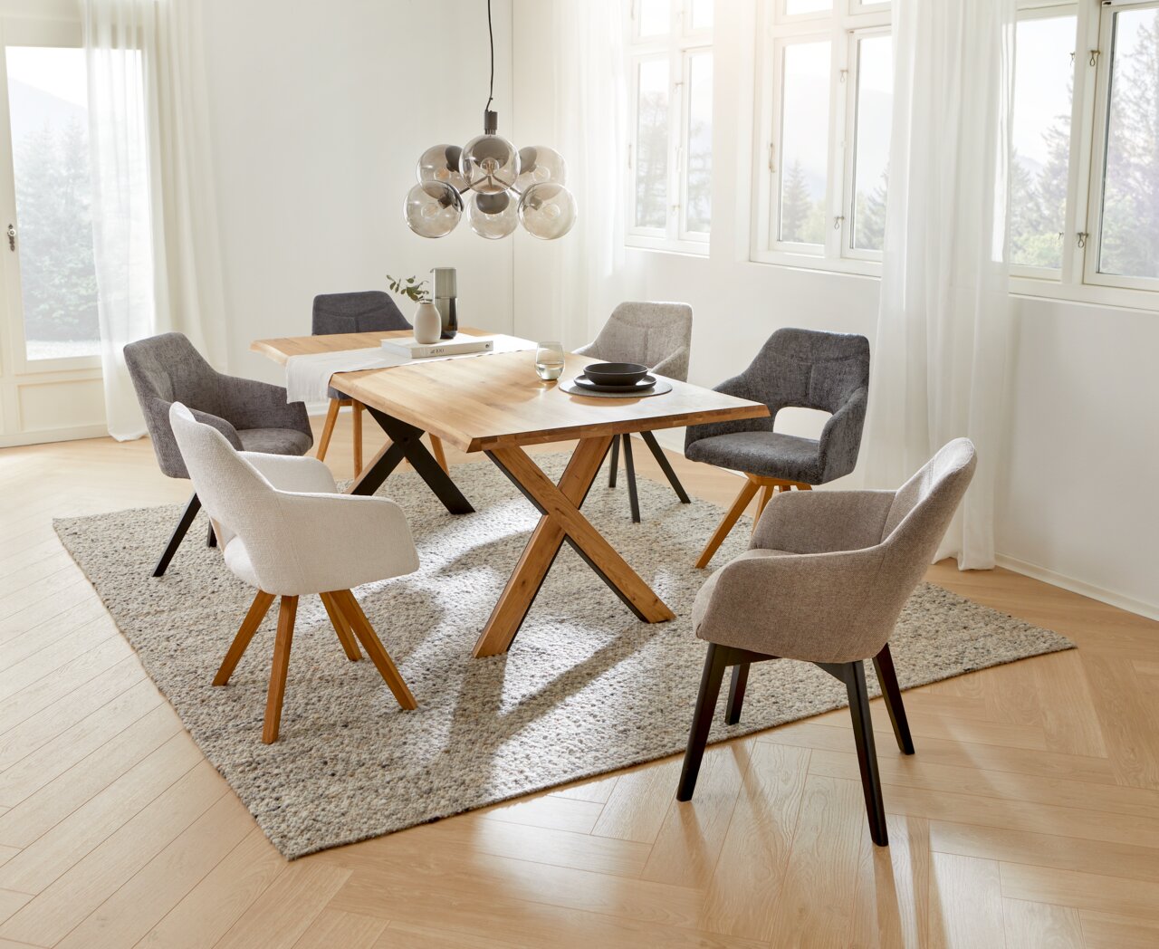 Esszimmer mit modernen Sesseln der Serie EVITA von Voleo, um einen Holztisch arrangiert. Helle und einladende Atmosphäre mit Blick aus der Vogelperspektive.