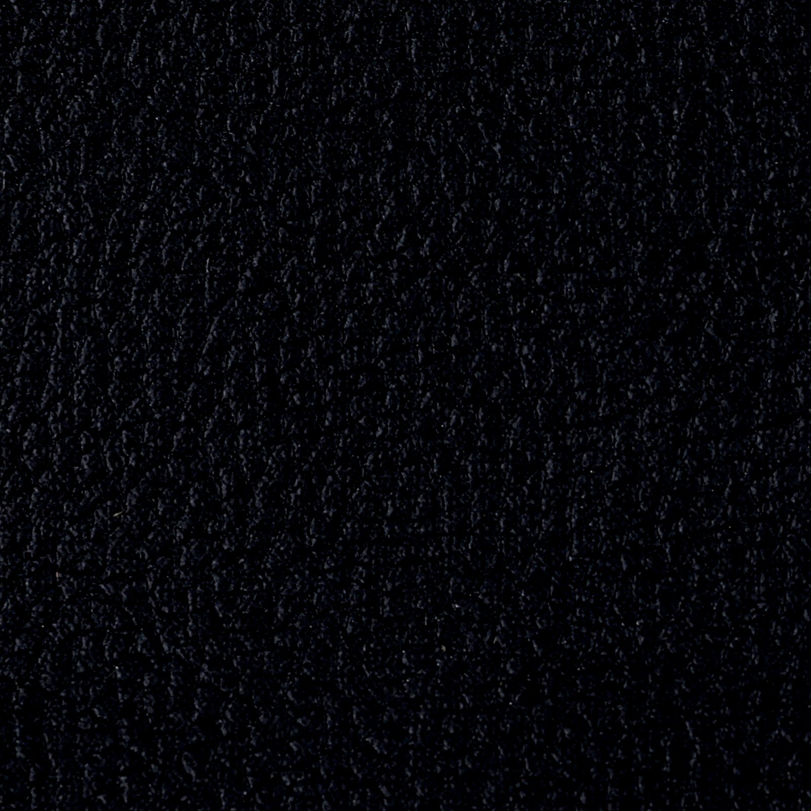 Nahaufnahme der schwarzen Lederstruktur eines Armlehnstuhls