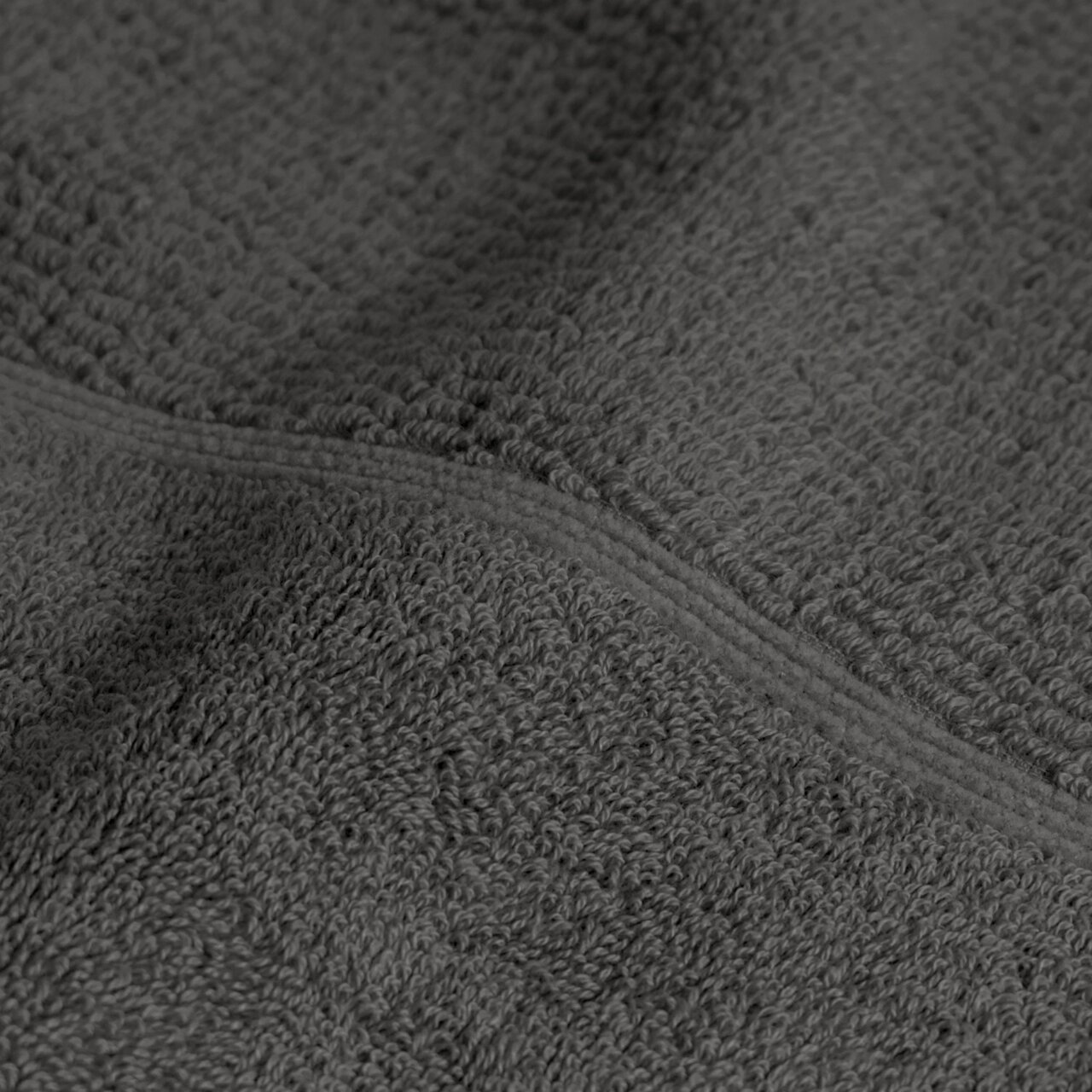 Close-up van een donkergrijze handdoek met een zachte textuur en een fijn weefpatroon.