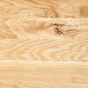 Nahaufnahme einer Holzoberfläche mit natürlicher Maserung und Astloch, von oben betrachtet.