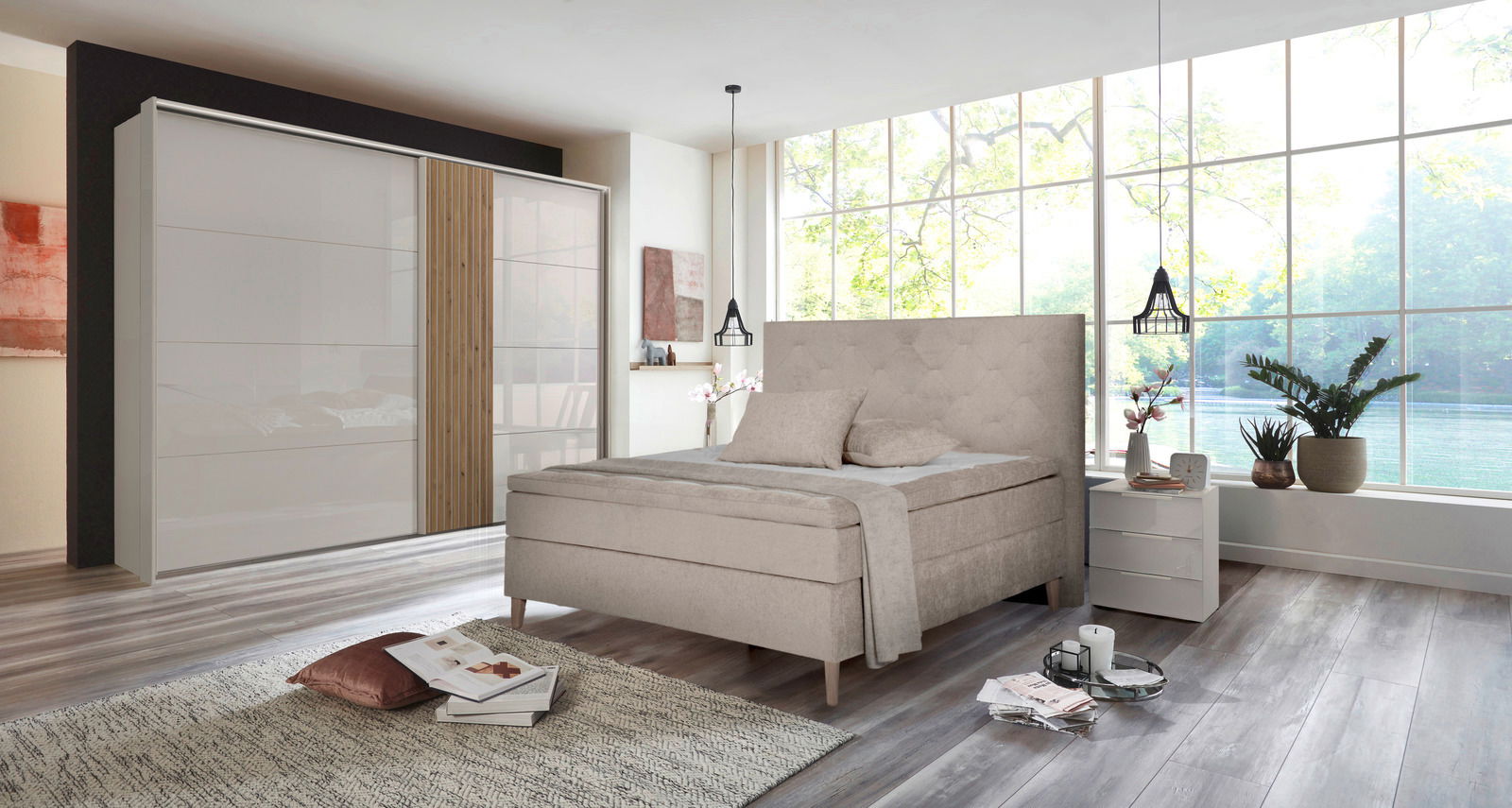 Modernes Schlafzimmer mit einem beigen Boxspringbett und einem zweiflügeligen Schwebetürenschrank, seitliche Perspektive.