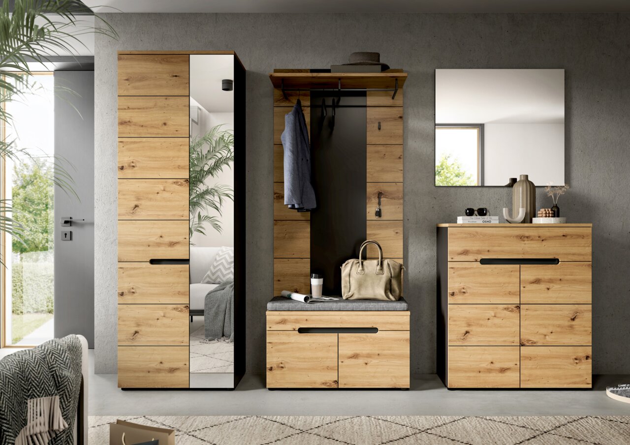 Moderne Garderobenmöbel im Flur: hoher Schrank mit Spiegel, Garderobenpaneel mit Sitzbank und Haken sowie Kommode mit Wandspiegel in Eiche-Optik und schwarzen Griffleisten, frontal aus Augenhöhe aufgenommen.