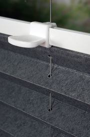 Nahaufnahme eines gefädelten Plissees in Anthrazit mit weißer Halterung, seitliche Perspektive.