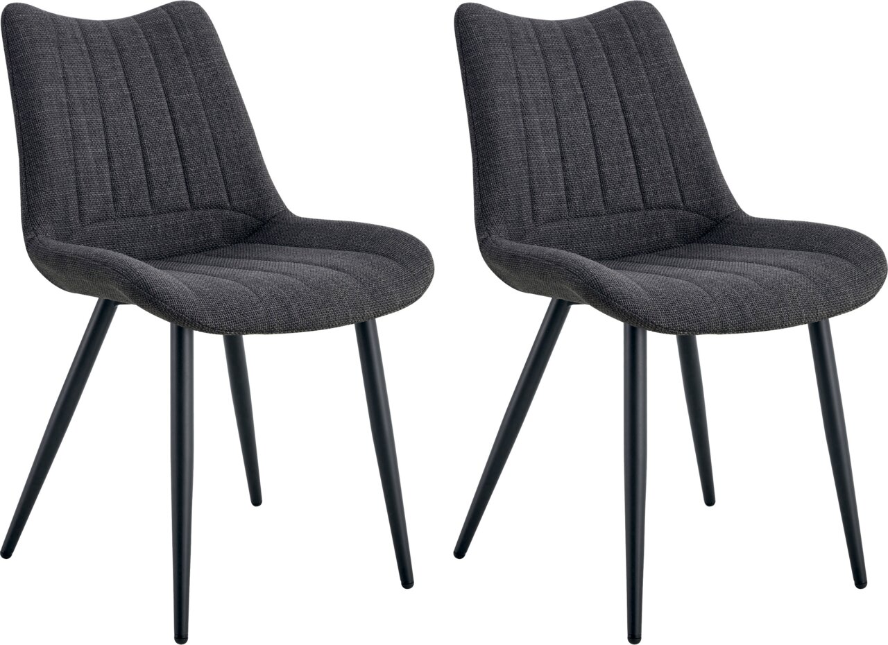 Zwei gepolsterte Esszimmerstühle in Dunkelgrau mit Stoffbezug, vertikaler Steppung und schwarzen Metallbeinen, schräg von vorne in leichter Seitenansicht freigestellt auf weißem Hintergrund