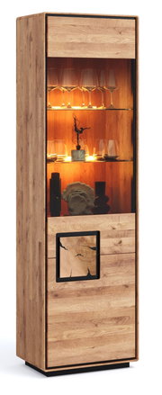 Hohe Holzvitrine in Eiche-Optik mit beleuchtetem Glasfach und Glasböden, teils geschlossener Front mit dekorativem Einsatz, gezeigt in leichter Schrägansicht von vorne links.