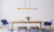 Moderne Hängeleuchte aus Holz über einem Esstisch, seitliche Perspektive