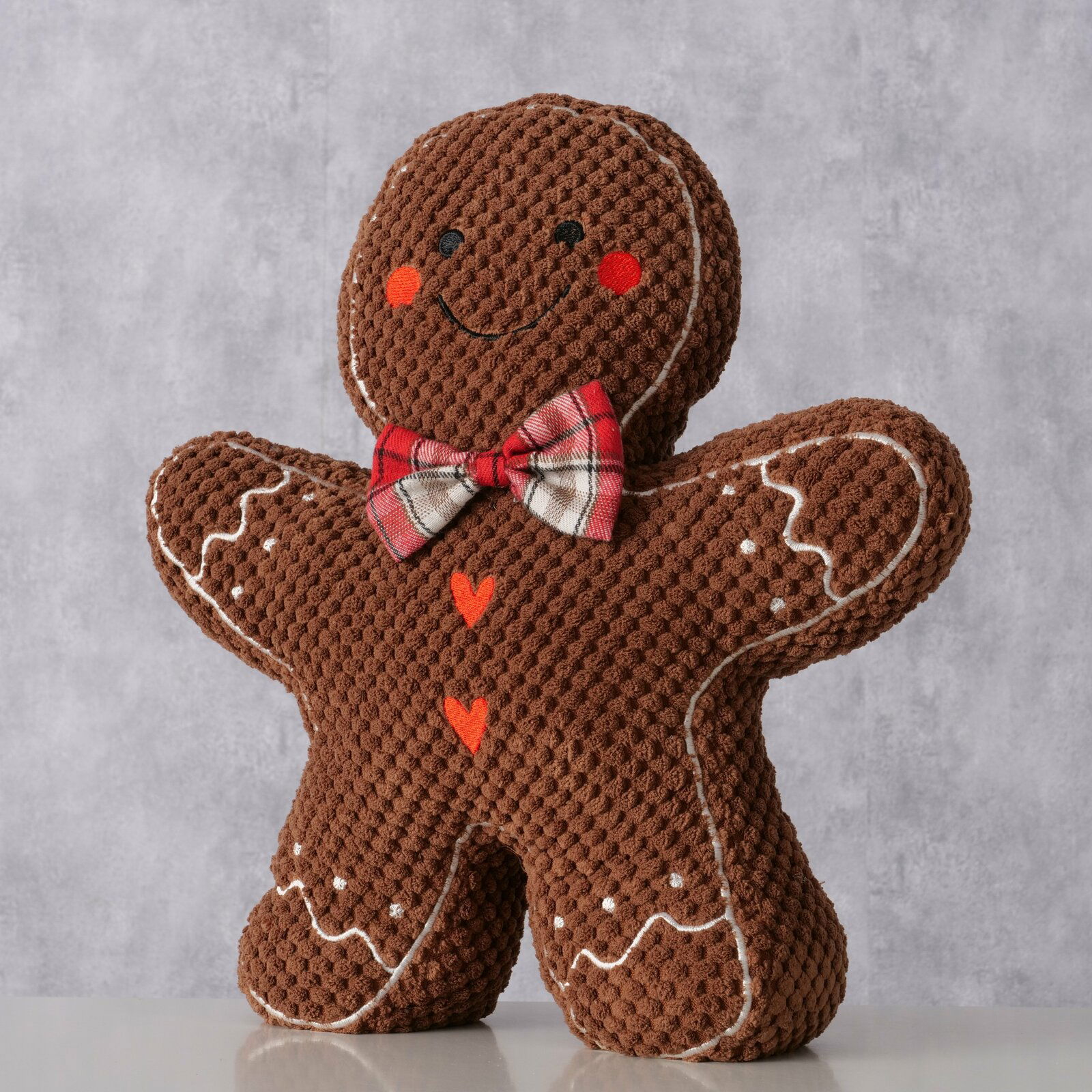 Türstopper in Form eines Lebkuchenmanns mit roter Fliege und Herzverzierungen, Frontalansicht.