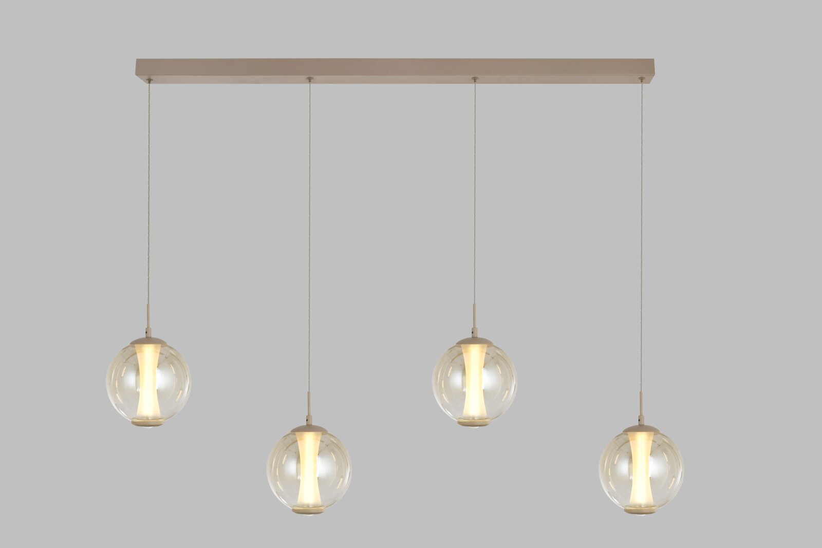 Vooraanzicht van een moderne vierlichts hanglamp met transparante glazen bollen, warmwitte verlichting en een langwerpige beige plafondplaat.