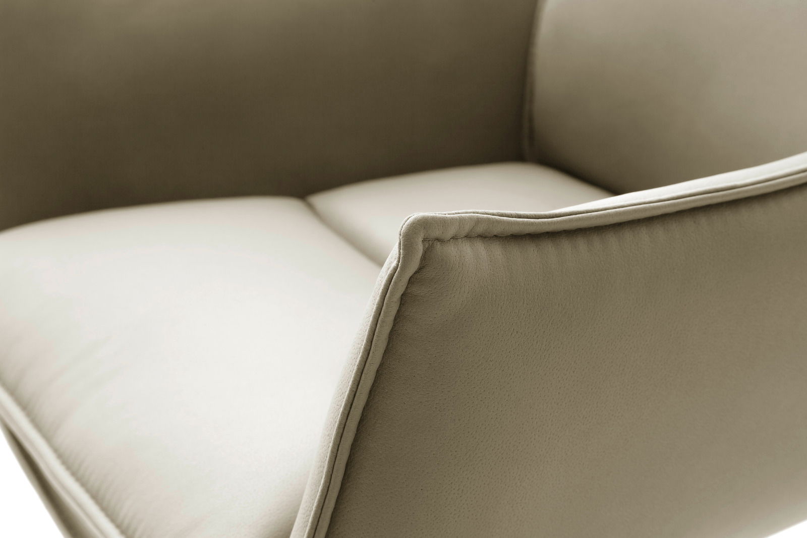 Nahaufnahme eines Sessels mit beigem Stoffbezug, seitliche Perspektive