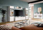 Modernes weißes Wohnzimmermöbel-Set mit TV-Lowboard, zwei Vitrinen und Sideboard vor petrolfarbener Wand, frontal aus leicht schräger Perspektive aufgenommen.