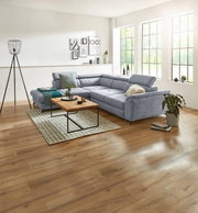 Eckgarnitur in einem modernen Wohnzimmer mit großen Fenstern, Holzboden und stilvoller Dekoration, seitliche Perspektive