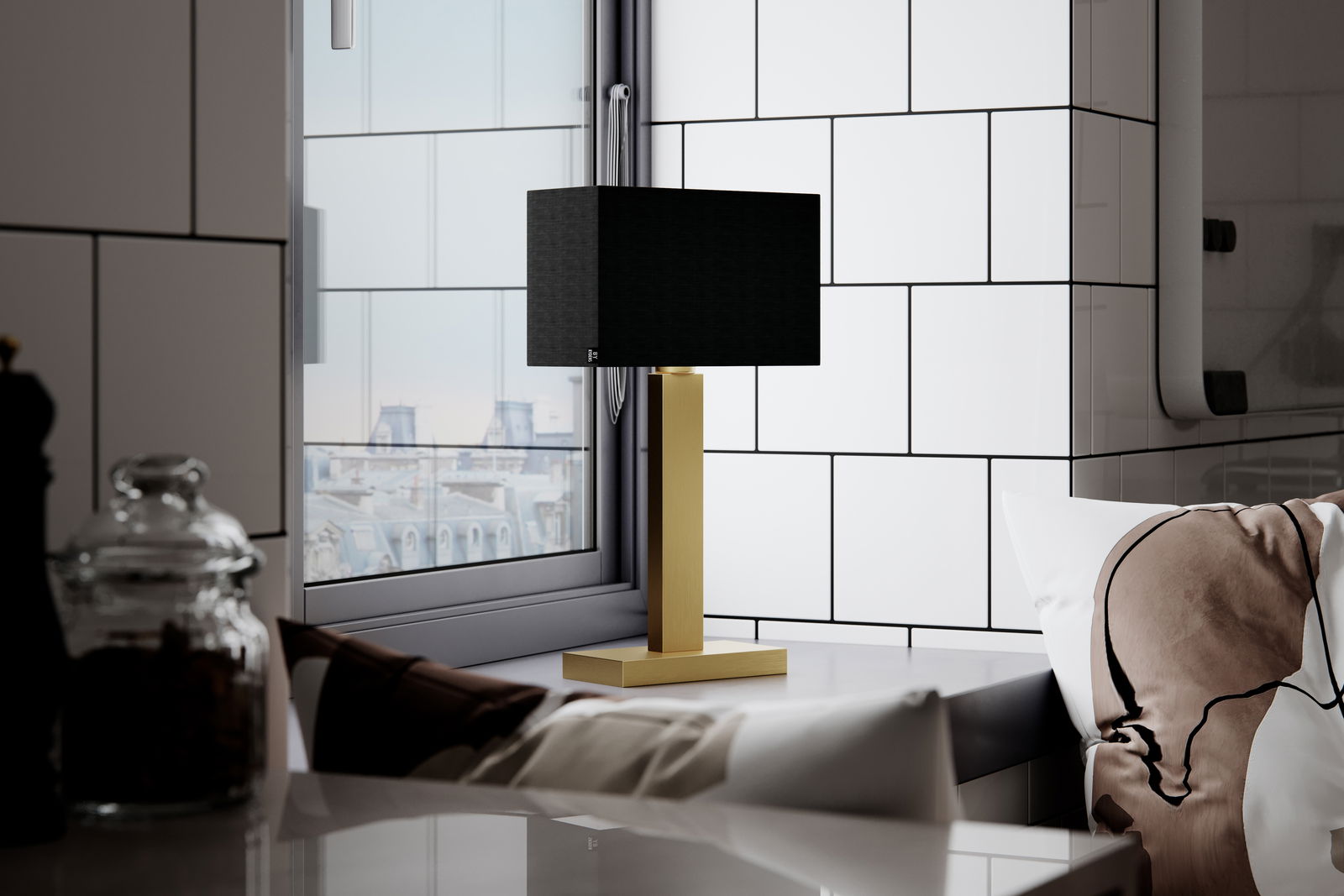 Moderne Tischleuchte PRIME mit schwarzem Schirm und goldfarbenem Sockel, seitlich auf einem Tisch vor einem Fenster platziert.