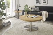 Moderner Couchtisch MONTEVERDE mit runder Holzplatte und Metallfuß, im Wohnzimmer mit Sofa und Dekoration, seitliche Perspektive.