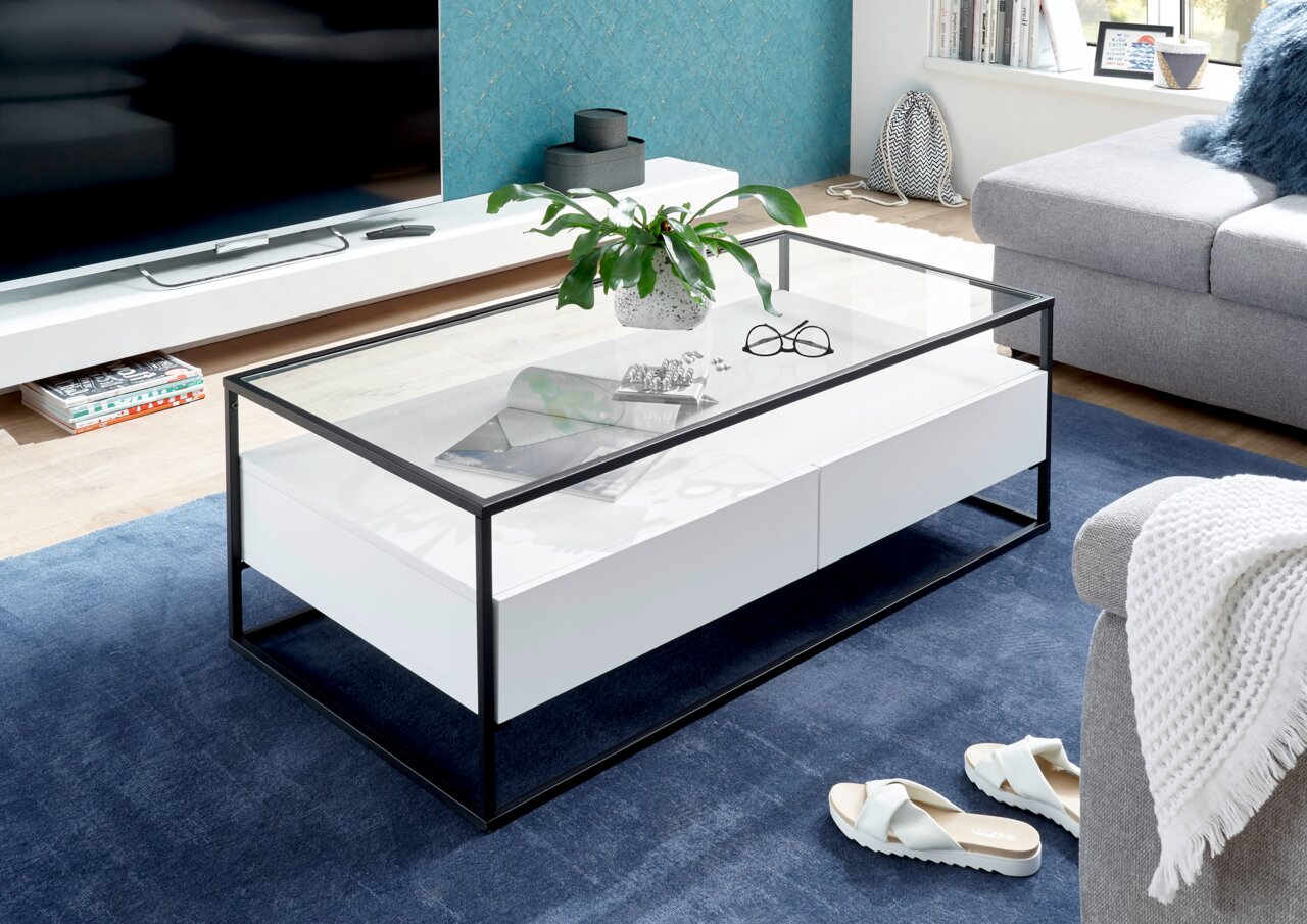 Moderner Couchtisch mit Glasplatte und schwarzem Metallrahmen, seitliche Perspektive