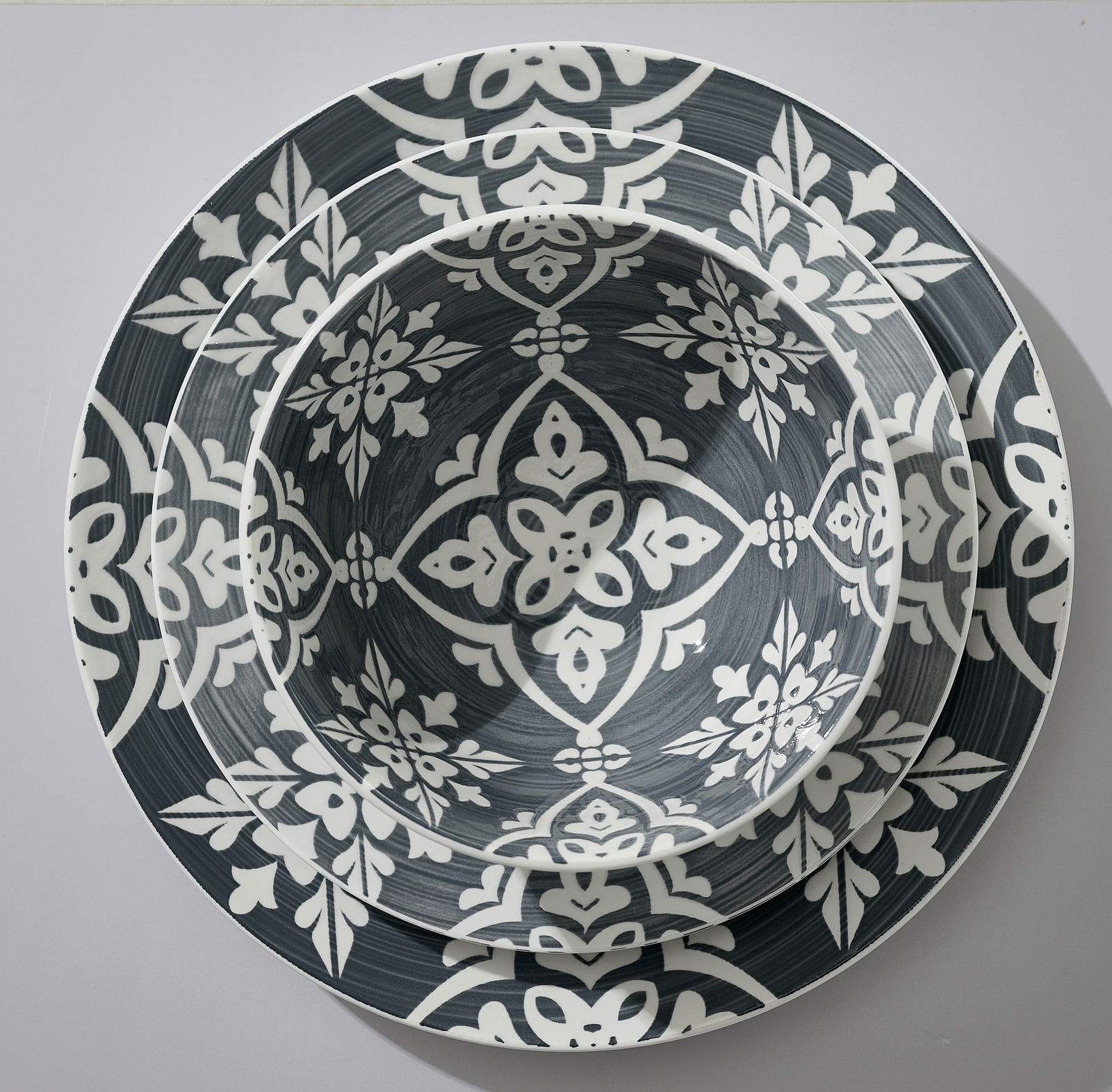 Draufsicht auf ein stilvolles, 16-teiliges Kombiset Salina mit dekorativem, floralen Muster in Grau und Weiß.