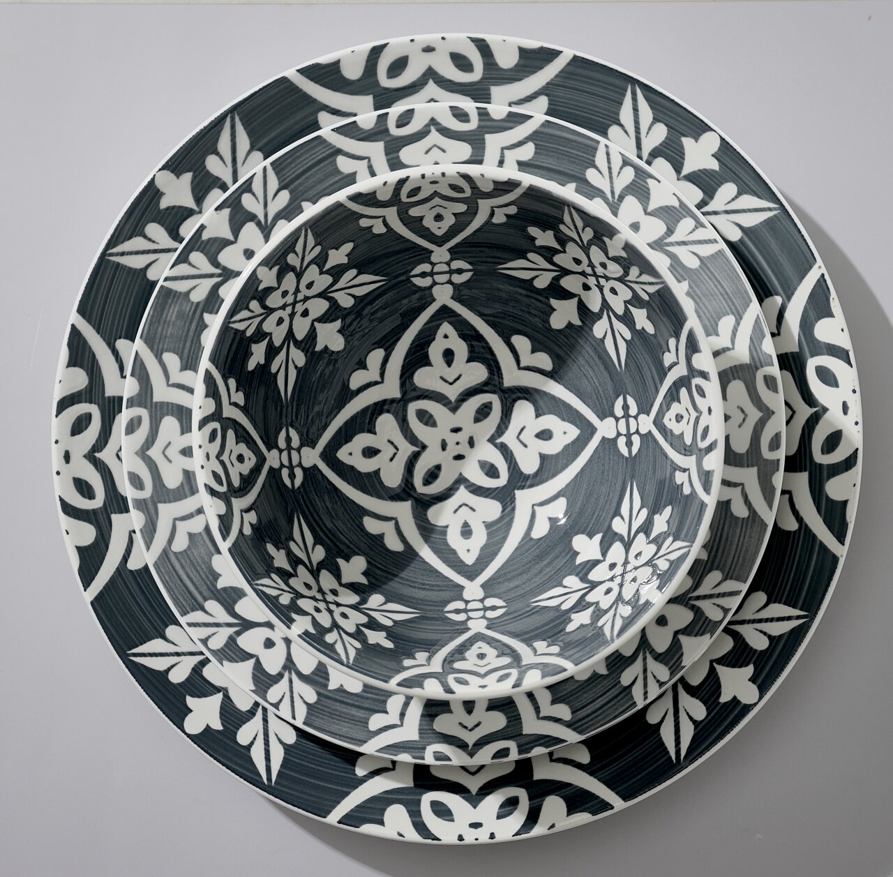 Bovenaanzicht van een stijlvolle, 16-delige Salina-set met een decoratief bloemmotief in grijs en wit.