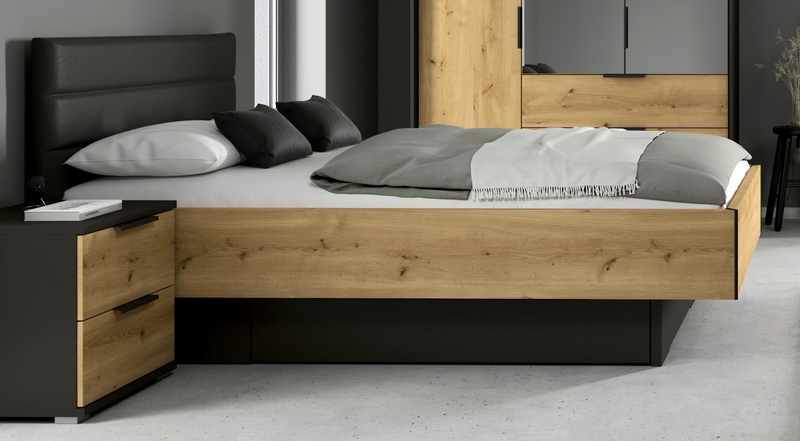 Modernes Doppelbett in Eiche-Optik mit schwarzem gepolstertem Kopfteil und integrierten Schubladen, seitliche Frontansicht im Schlafzimmer-Setting