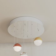 Mehrere kugelförmige LED-Hängeleuchten in verschiedenen Metalltönen, von unten betrachtet.