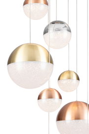 Mehrere kugelförmige LED-Hängeleuchten in verschiedenen Metalltönen, von unten betrachtet.