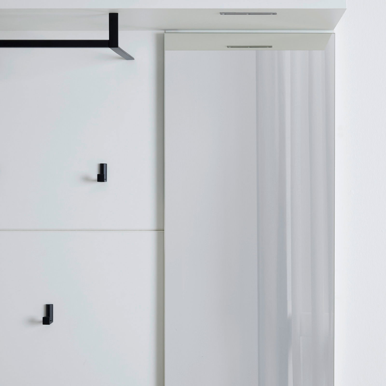 Modernes Garderobenpaneel mit schwarzem Haken und Spiegel, seitliche Perspektive