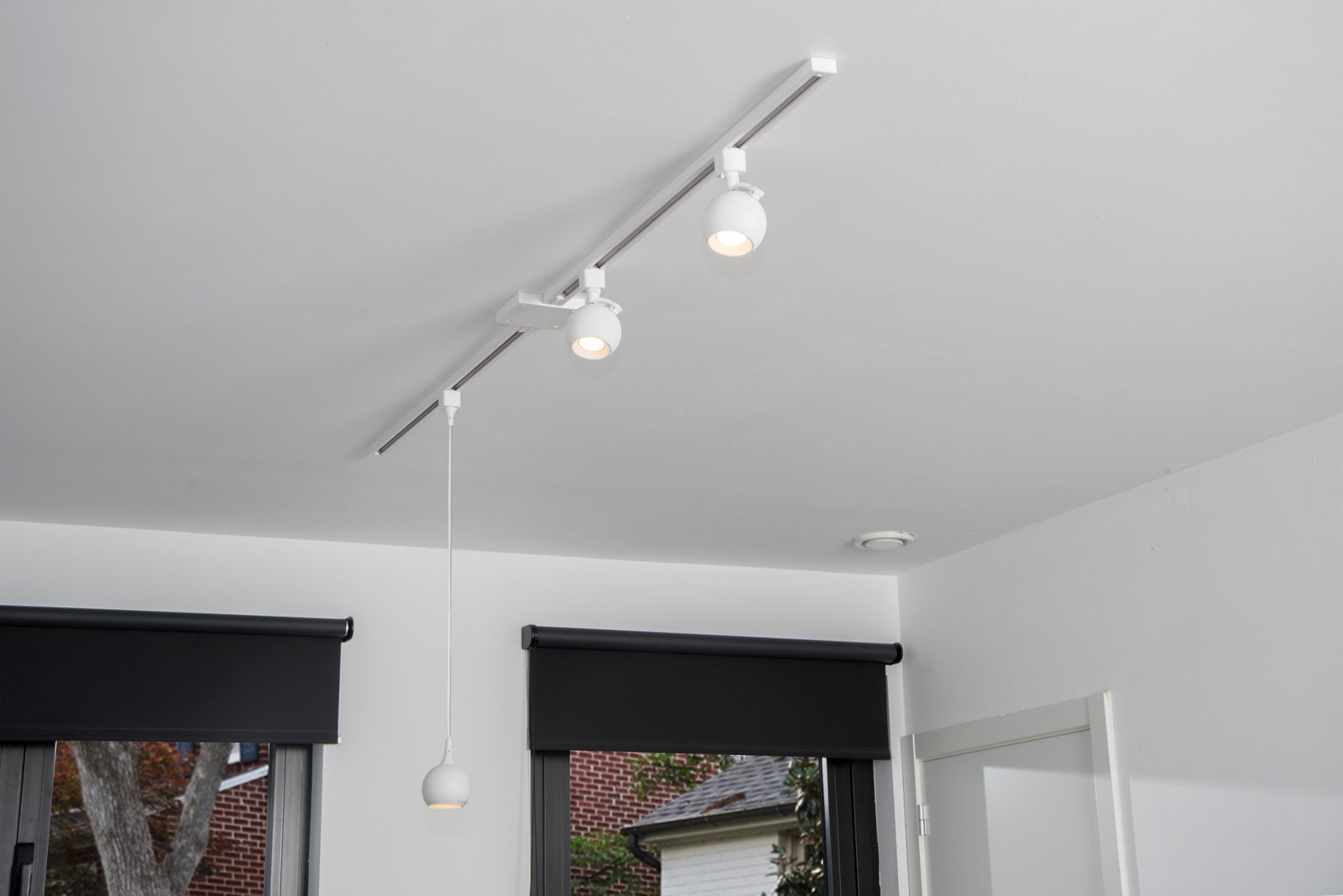 Deckenstrahler FAVORI in Weiß, montiert an einer Schiene an der Decke, Perspektive von unten.