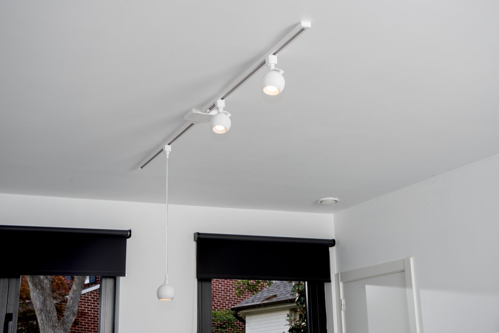 Deckenstrahler FAVORI in Weiß, montiert an einer Schiene an der Decke, Perspektive von unten.