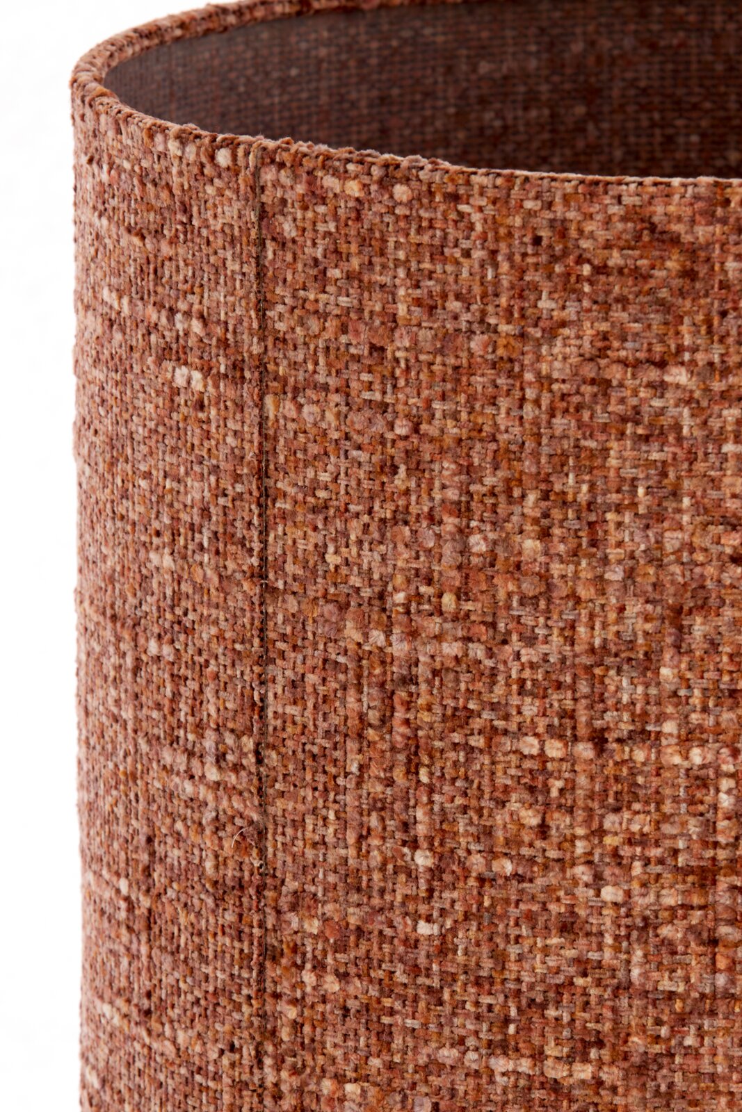 Close-up vanuit schuin bovenaanzicht van een cilindervormige lampenkap in warm roestbruin bouclétextiel, met zicht op de rijke geweven structuur en binnenzijde.