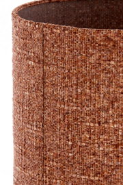 Close-up vanuit schuin bovenaanzicht van een cilindervormige lampenkap in warm roestbruin bouclétextiel, met zicht op de rijke geweven structuur en binnenzijde.