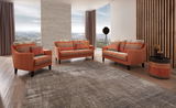 Wohnzimmer mit drei orangefarbenen Sofas im orientalischen Design, dekoriert mit gemusterten Kissen, aus der Perspektive von vorne fotografiert.